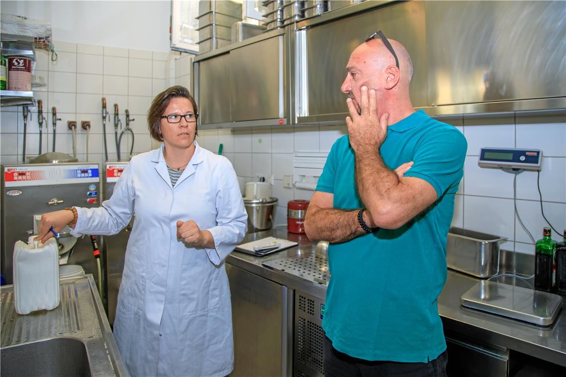 Angelika Kliemank weist den Speiseeishersteller Luca Schiffo auf die korrekte Verwendung von Desinfektionsmittel hin. Foto: Stefan Bossow