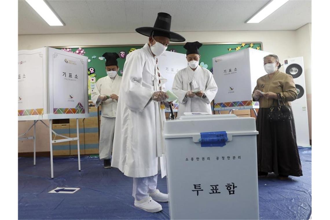 Südkoreas Regierungspartei bei Parlamentswahl mit Sieg Anhänger der konfuzianischer Lehre mit Mundschutz und Einmalhandschuhe während ihrer Stimmabgabe in einem Wahllokal in Nonsan. Foto: Kim Jun-Beom/Yonhap/dpa