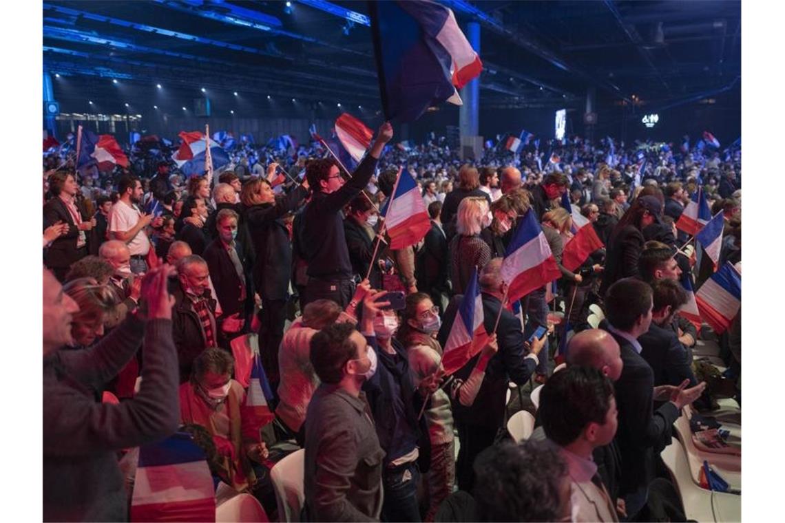 Anhänger des rechtsextremen französischen Präsidentschaftskandidaten Éric Zemmour schwenken Plakate und französische Flaggen. Foto: Rafael Yaghobzadeh/AP/dpa