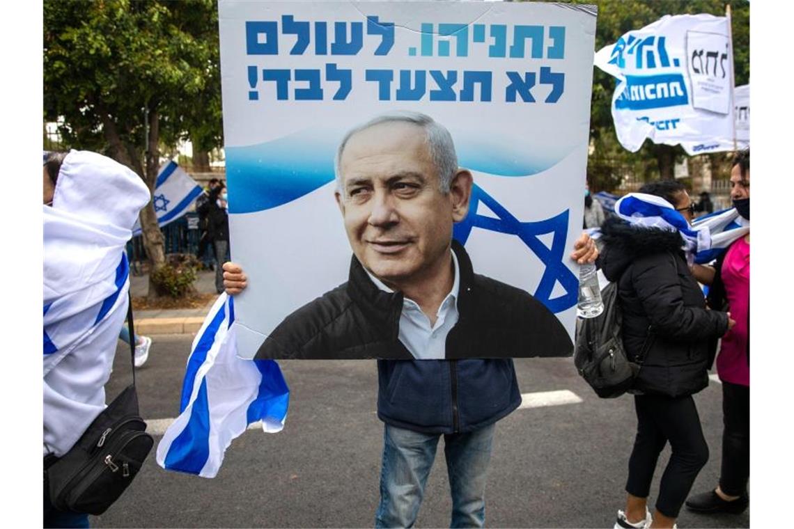 Spektakulärer Korruptionsprozess gegen Netanjahu eröffnet Anhänger von Ministerpräsident Netanjahu schwenken Fahnen und halten Plakate vor seiner Residenz in Jerusalem hoch. Foto: Ariel Schalit/AP/dpa