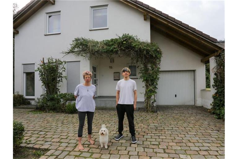 Anja Kassenpecher und ihr Sohn Dennis stehen vor ihrer vorübergehenden Bleibe im nordrhein-westfälischen Kuckum. Bei der Flutkatastrophe Mitte Juli wurde das Haus der Familie aus Ahrweiler zerstört. Foto: Ralf Roeger/dpa