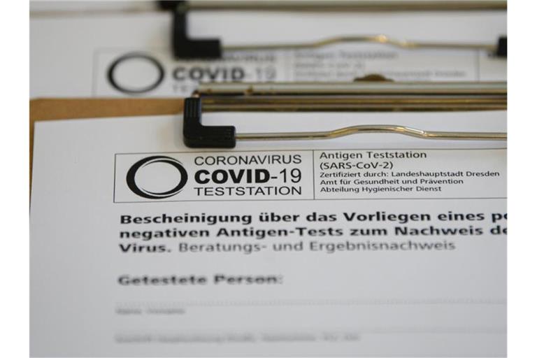 Anmeldebögen in einer Corona-Teststation in einem Cafè in der Dresdner Neustadt. Foto: Robert Michael/dpa-Zentralbild/ZB