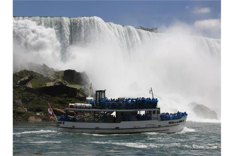 Annäherung per Touristenboot: Die „Maid of the Mist“ fährt an die Niagarafälle heran. Foto: David Duprey/AP/dpa