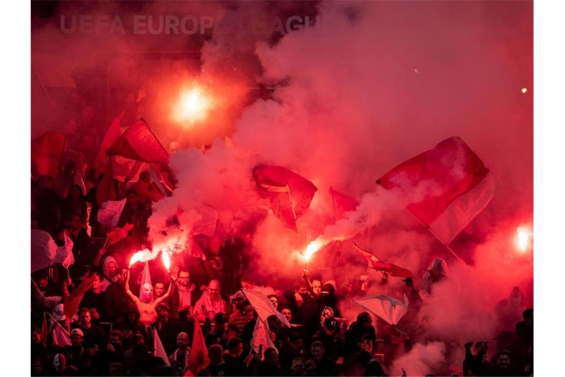 Antwerpen-Fans schwenken vor der Partie Bengalos. Foto: Marius Becker/dpa