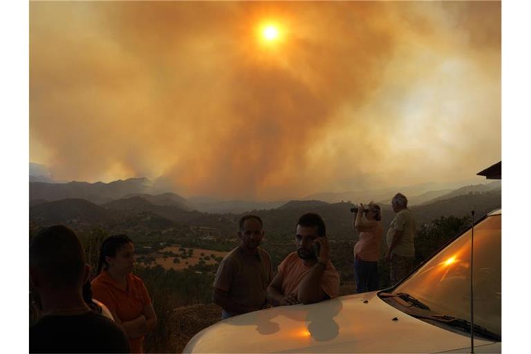 Anwohner beobachten den Waldbrand in der Bergregion von Larnaka auf Zypern. Foto: Petros Karadjias/AP/dpa