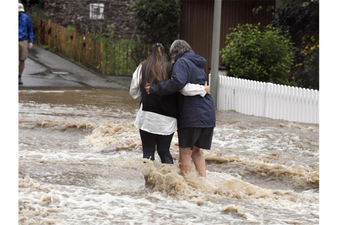 Anwohner der Ortschaft Balken helfen sich durch Fluten der Wupper. Foto: Roberto Pfeil/dpa