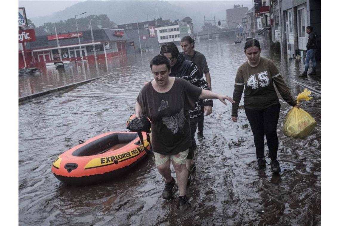 Zahl der Hochwasser-Toten in Belgien steigt auf 23 Anwohner in Lüttich waten mit einem Gummiboot durch das Wasser, nachdem die Maas bei schweren Überschwemmungen über die Ufer getreten ist. Foto: Valentin Bianchi/AP/dpa