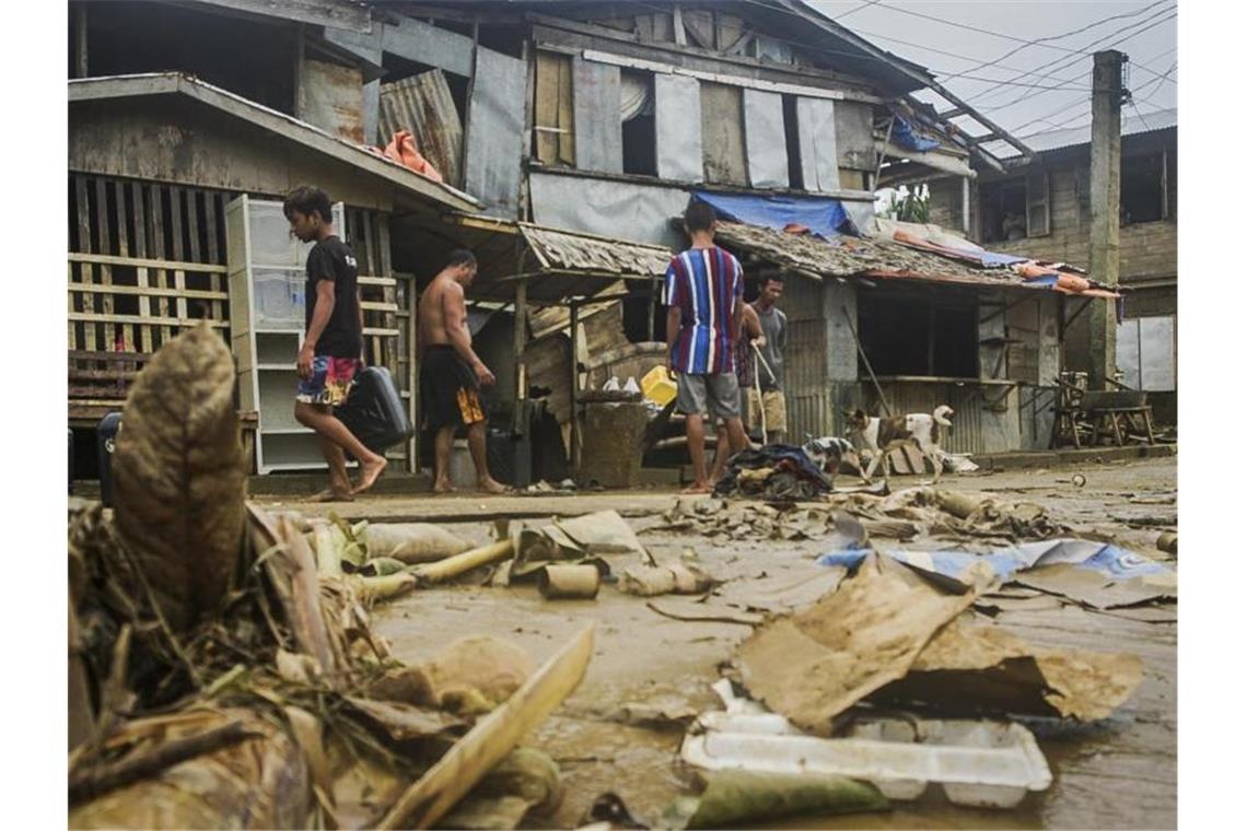 Philippinen: Mindestens sieben Tote durch Taifun „Surigae“ Anwohner räumen Trümmer von den Überschwemmungen durch den Taifun "Surigae" auf. Foto: Uncredited/AP/dpa