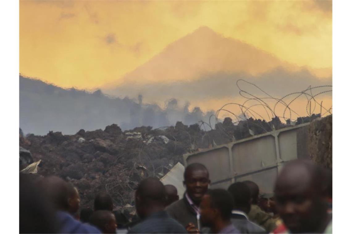 Lavastrom stoppt kurz vor afrikanischer Großstadt Anwohner überprüfen in den frühen Morgenstunden die durch die Lava verursachten Schäden. Foto: Justin Kabumba/AP/dpa