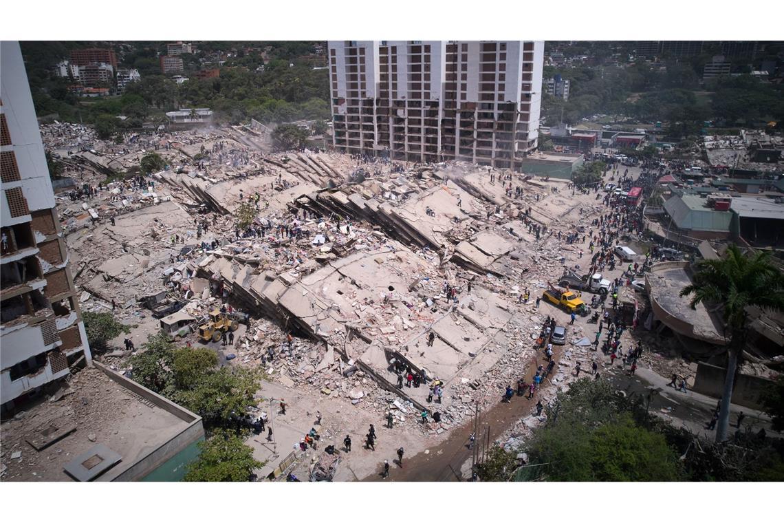 Anwohner und Rettungskräfte durchsuchen zwei Tage nach den Erdbeben in Venezuela Trümmer in La Guaira.