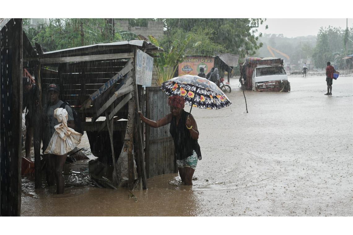 Anwohner waten durch eine überflutete Straße nach dem durchzug von Hurrikan Melissa in Petit-Goave.