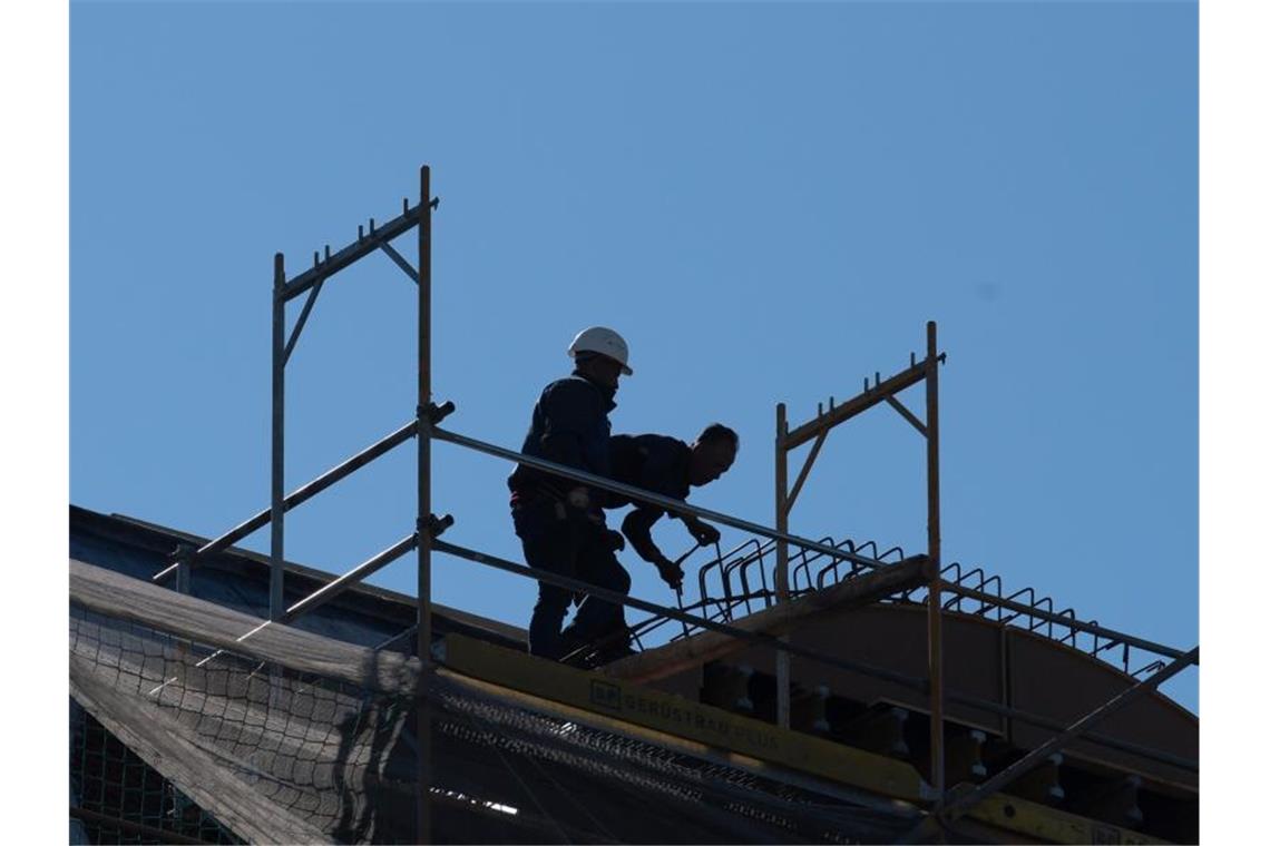 Arbeiter arbeiten auf einem Dach. Foto: Paul Zinken/dpa-zentralbild/dpa/Symbolbild