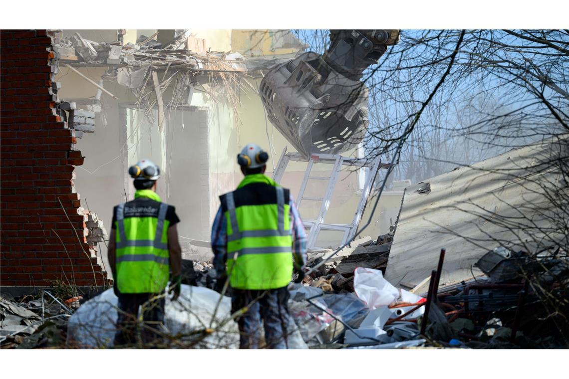 Arbeiter beobachten die Abrissarbeiten eines Baggers am Haus Seeblick am Brodtener Steilufer an der Ostsee.