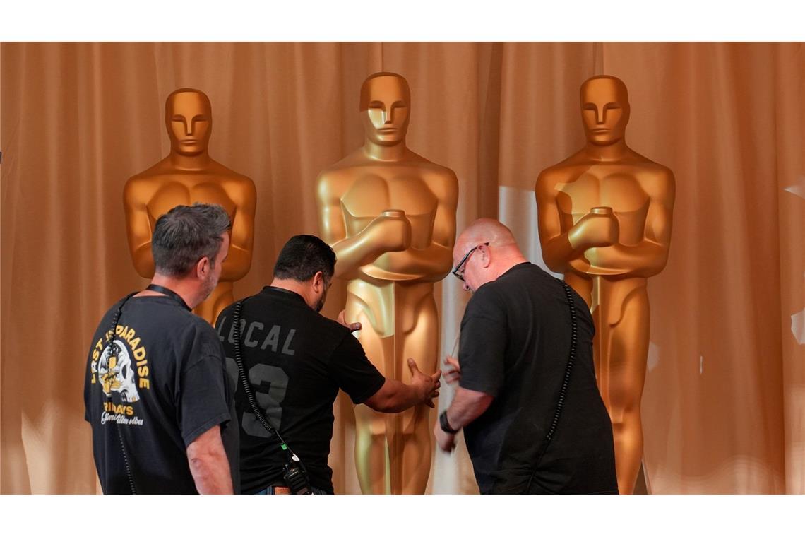 Arbeiter bewegen Oscar-Statuen entlang des roten Teppichs vor der Oscar-Verleihung in Los Angeles.