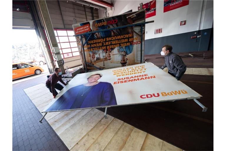 Arbeiter bringen bei ein Wahlplakat der baden-württembergischen CDU zu einem Anhänger. Foto: Marijan Murat/dpa/Archivbild