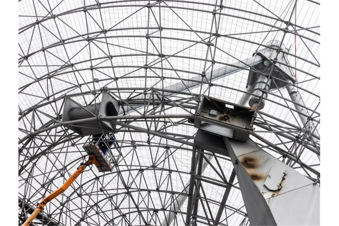 Parabolantenne weicht Achterbahn im Europa-Park Arbeiter entfernen die letzten Bolzen eines stählernen Dreibeins auf einer Parabolantenne. Foto: Philipp von Ditfurth/dpa