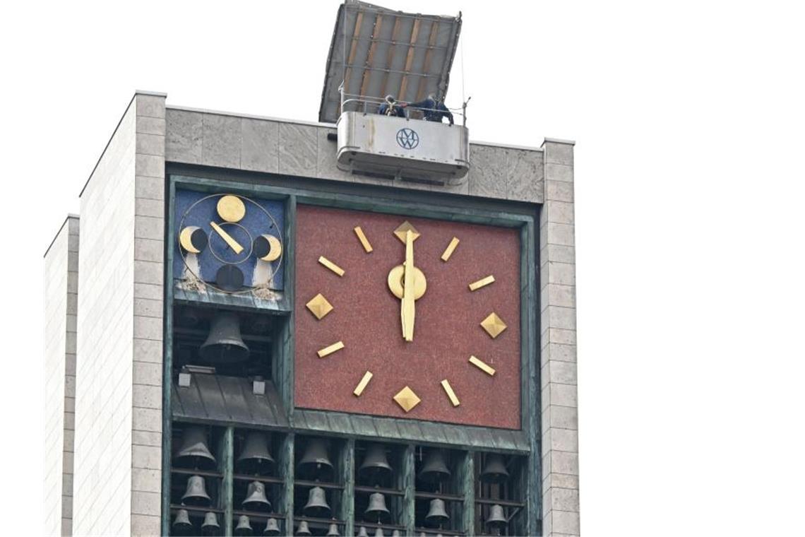 Die Uhren ticken wieder: Reparatur am Rathaus abgeschlossen Arbeiter haben nach einer Restaurierung die Zeiger der Turmuhr am Stuttgarter Rathaus wieder angebracht. Foto: Bernd Weißbrod/dpa