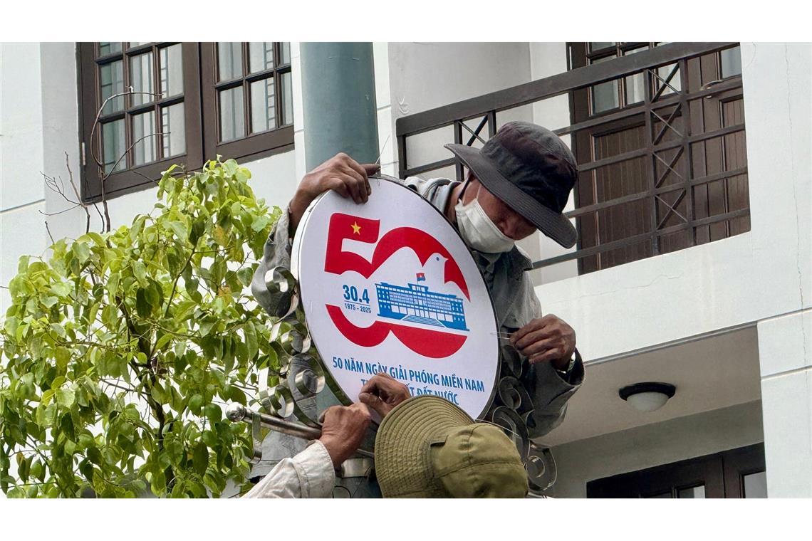 Bilder des Tages Arbeiter installieren ein Schild zum 50. Jahrestag des Endes des Vietnamkrieges in Ho-Chi-Minh-Stadt.