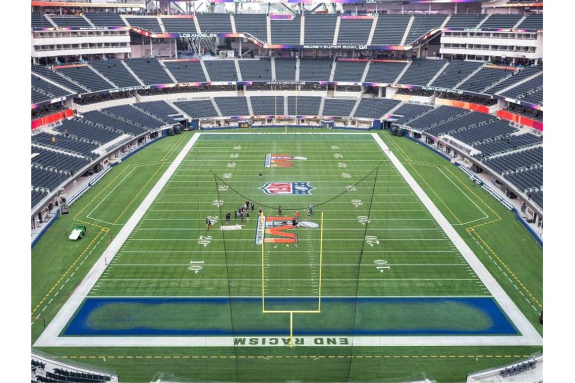 Was muss ich wissen über den 56. Super Bowl der NFL? Arbeiter malen das Logo des Super Bowl LVI auf das Spielfeld im SoFi Stadion. Foto: Maximilian Haupt/dpa