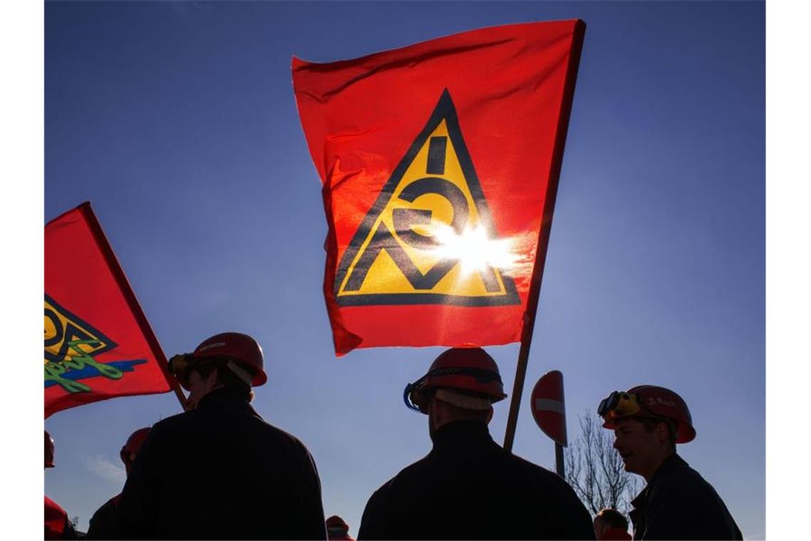 Arbeiter mit Fahnen mit dem Logo der IG Metall. Foto: Jens Büttner/dpa-Zentralbild/dpa/Archivbild