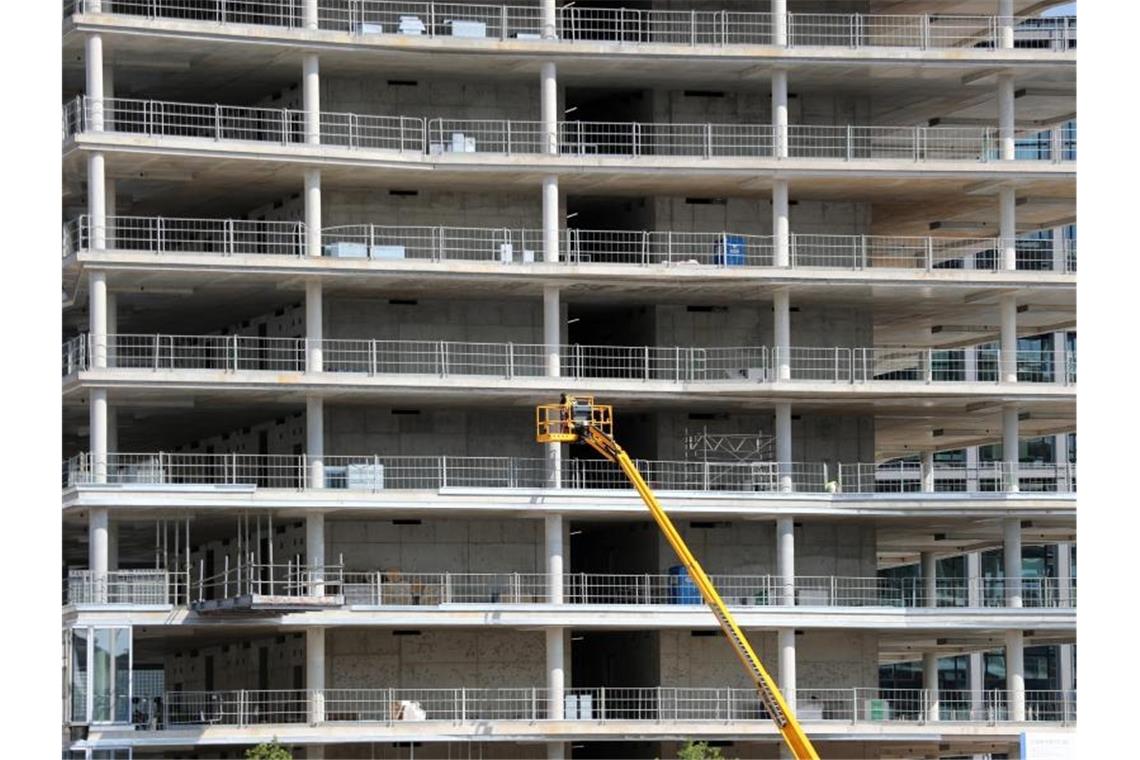 Zu wenige Wohnungen in Metropolen im Südwesten Arbeiter montieren von einer Hebebühne aus Teile an einem Neubau. Foto: Jens Büttner/Archiv