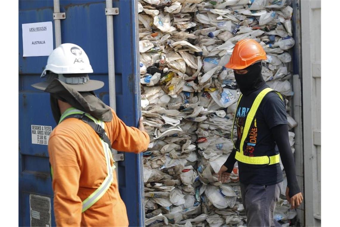 Arbeiter öffnen in Malaysia einen Container voller nicht recycelbarer Kunststoffe. 2020 wurden 151.000 Tonnen Plastikmüll nach Malaysia verschifft. Foto: Vincent Thian/AP/dpa