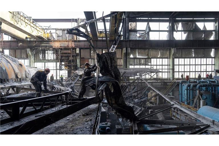 Arbeiter räumen die Trümmer nach einem russischen Raketenangriff auf ein DTEK-Kraftwerk in der Ukraine auf.