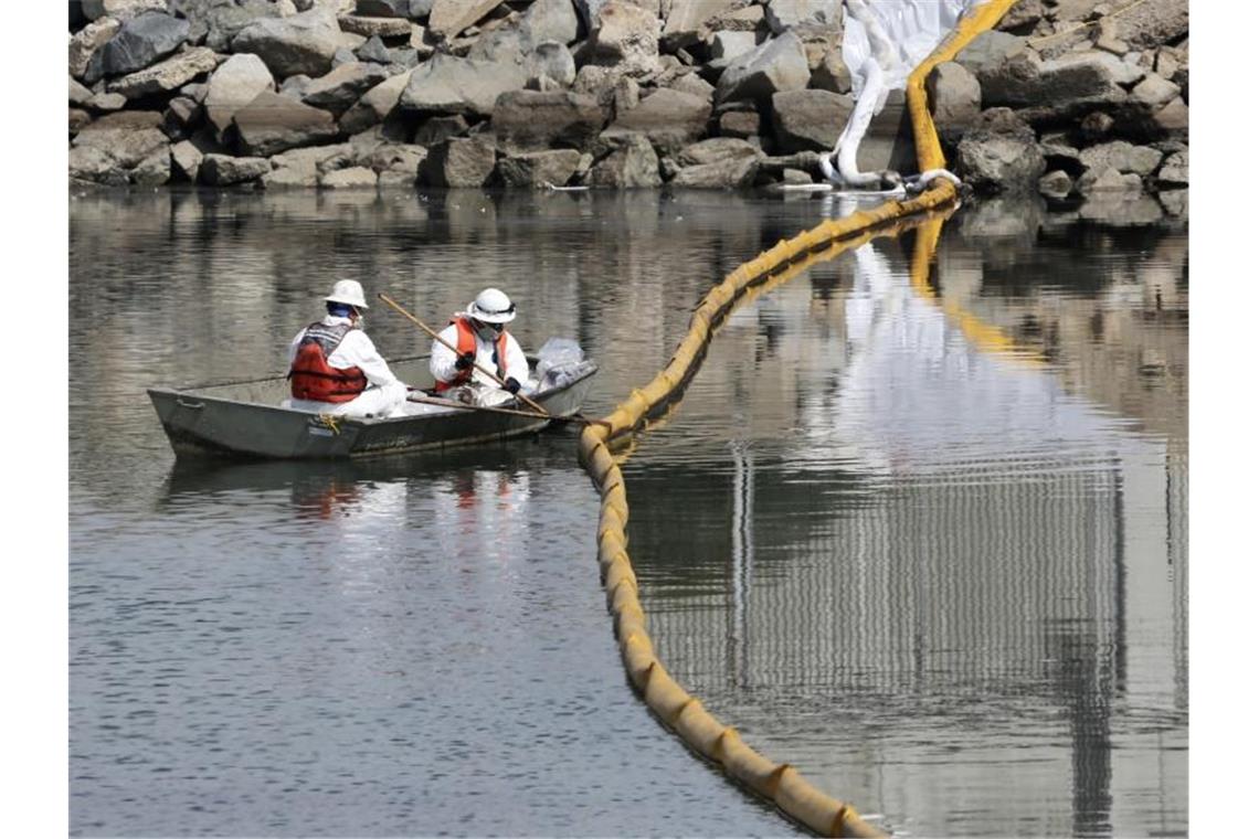Arbeiter sammeln Öl aus dem Meerwasser in Huntington Beach. Foto: -/XinHua/dpa