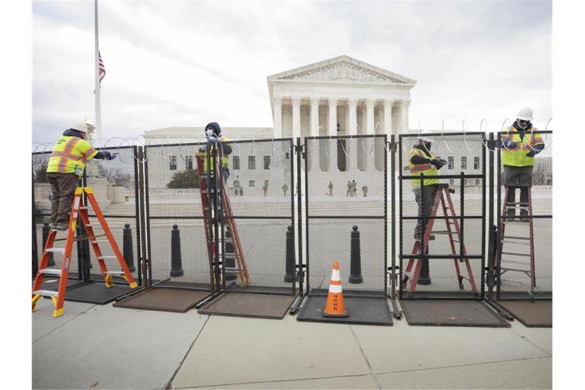 Arbeiter stehen am Sicherheitszaun vor dem US-Kapitol (Archivfoto vom 22. Januar). Foto: Mark Finkenstaedt/ZUMA Wire/dpa