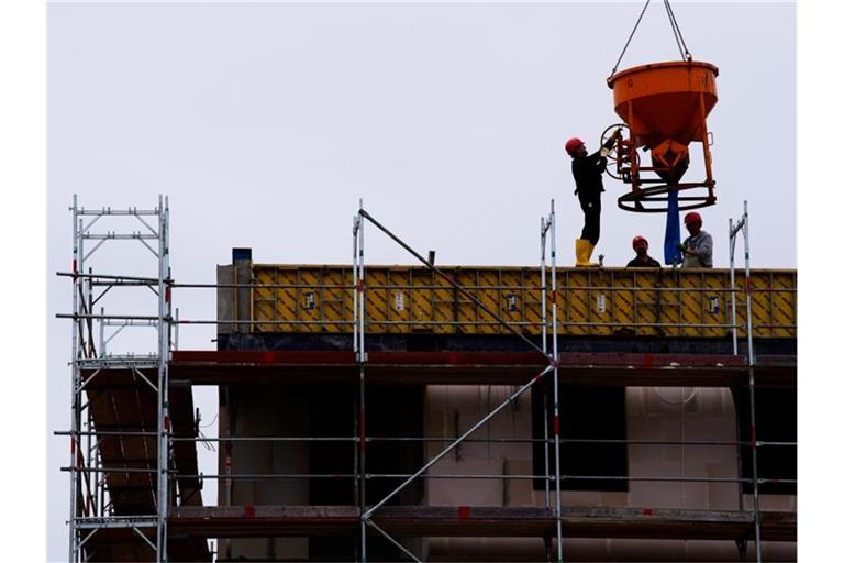 Arbeiter stehen auf einer Baustelle eines Wohngebäudes. Foto: Soeren Stache/dpa-zentralbild/dpa/Symbolbild