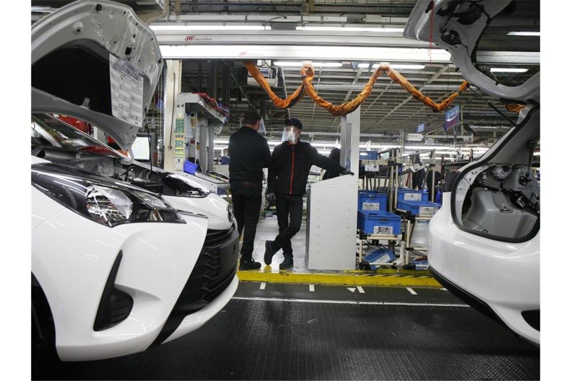 Arbeiter stehen mit Mundschutz in einer Toyota-Fabrik im französischen Onnaing. Foto: Michel Spingler/AP/dpa