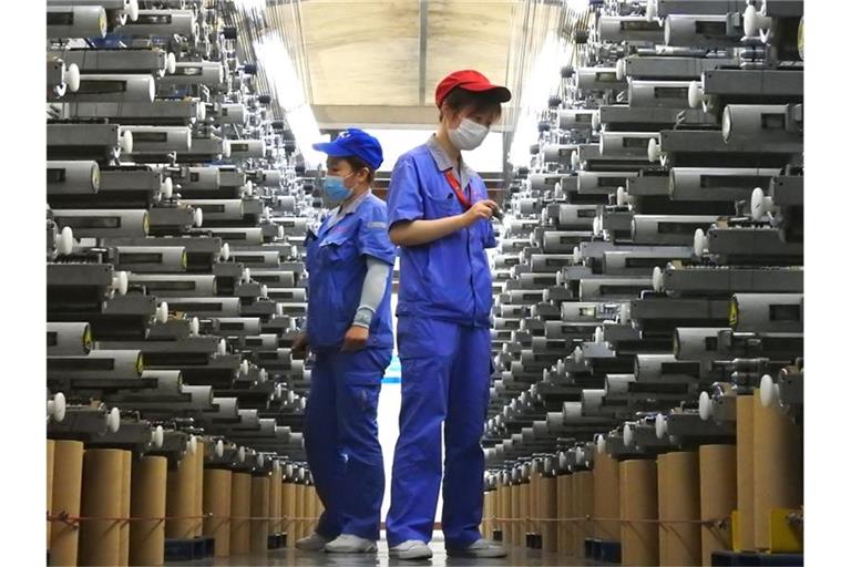 Arbeiter überprüfen eine Produktionslinie im Lianyungang Economic and Technological Development Area in Lianyungang in der ostchinesischen Provinz Jiangsu. Foto: Geng Yuhe/XinHua/dpa