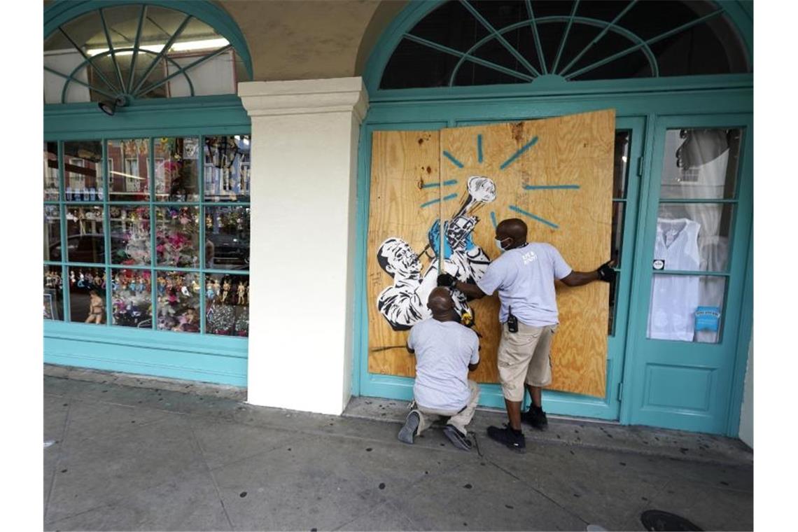 Arbeiter vernageln in Vorbereitung auf Sturm „Marco“ die Scheiben eines Geschäfts in New Orleans. Foto: Gerald Herbert/AP/dpa