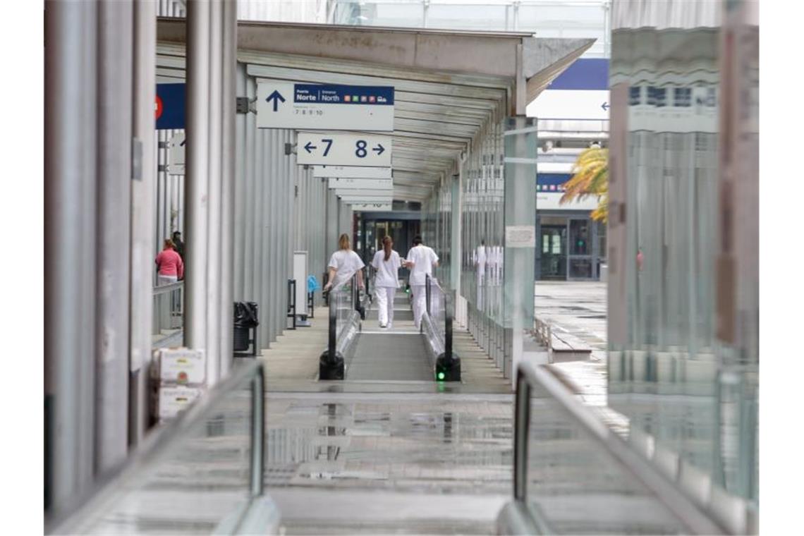Corona-Krise: Spanien optimistisch trotz Toten-Rekords Arbeiterinnen gehen einen Korridor im provisorischen Krankenhaus auf der Madrider Messe entlang. Foto: Ricardo Rubio/Europa Press/dpa