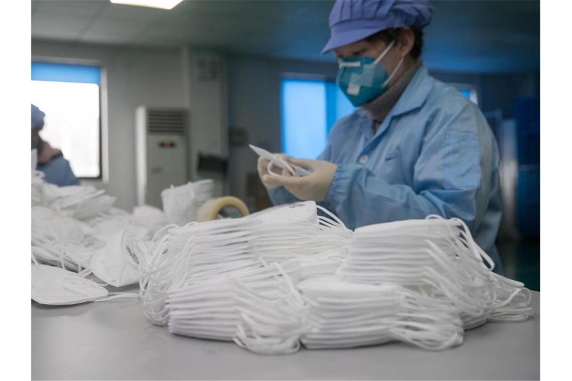 Arbeiterinnen zählen Atemschutzmasken in einer Fabrik in Shanghai. Foto: Ding Ting/Xinhua/dpa
