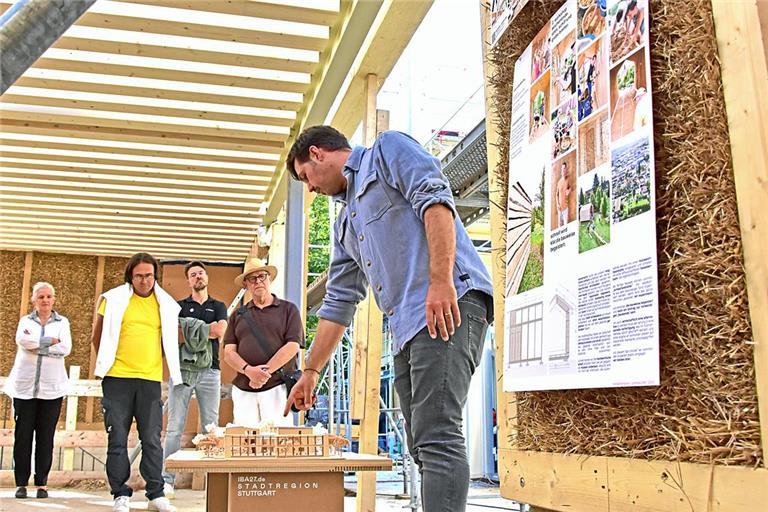 Architekt Lukas Brenner stellt das Wohnprojekt und das verwendete Baumaterial vor. Die herkömmlichen Holzständerwände werden in der Halle der Zimmerei mit Stroh von der Schwäbischen Alb gefüllt und auf diese Art vorgefertigt zur Baustelle gebracht. Fotos: Tobias Sellmaier
