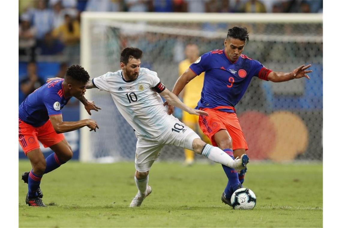 Argentiniens Superstar Lionel Messi (M) wird von zwei Kolumbianern unter Druck gesetzt. Foto: Natacha Pisarenko/AP