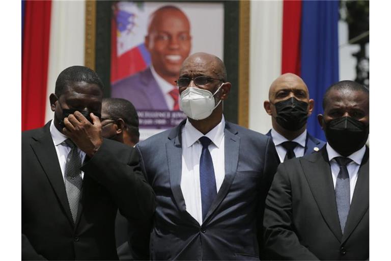 Ariel Henry (M), designierter Premierminister von Haiti, und Interims-Regierungschef Claude Joseph (r) stehen vor einem Porträt des ermordeten haitianischen Präsidenten Jovenel Moise. Foto: Joseph Odelyn/AP/dpa