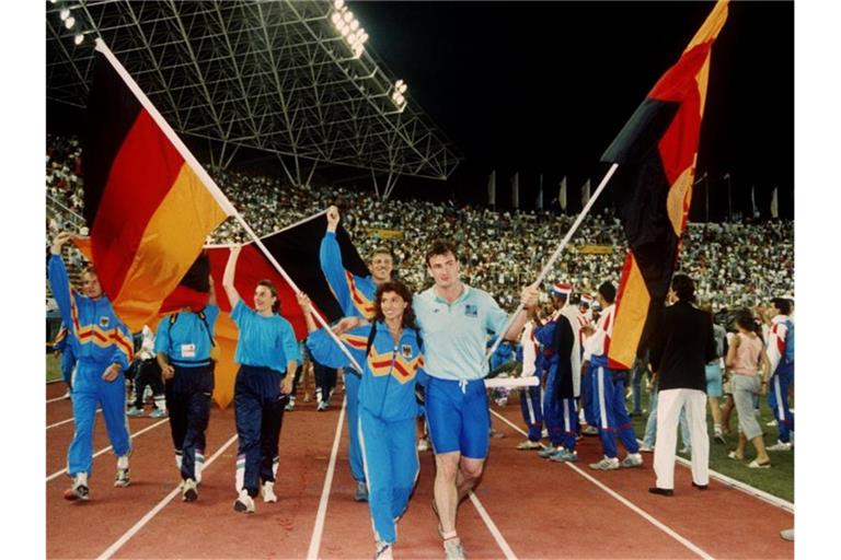 Arm in Arm: Fahnenträger Gabriele Lippe aus der Bundesrepublik und Ulf Timmermann aus der DDR 1990 bei der Schlußfeier der Leichtathletik-EM im jugoslawischen Split. Foto: -/dpa