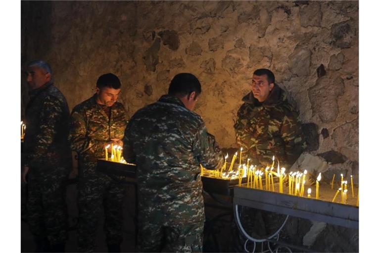Armenische Soldaten entzünden Kerzen in einem orthodoxen Kloster in Berg-Karabach. Foto: Sergei Grits/AP/dpa