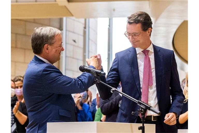 Armin Laschet (l,), Ministerpräsident von Nordrhein-Westfalen, gratuliert Landesverkehrsminister Hendrik Wüst (beide CDU) zur Nominierung als Regierungs- und Landesparteichef. Foto: Marcel Kusch/dpa