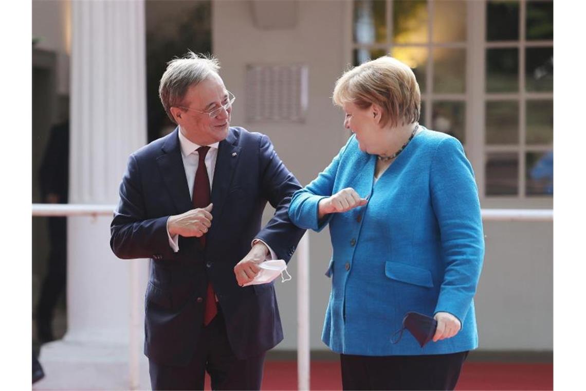 Laschet dankt Merkel für Führungskraft in Krisen Armin Laschet und Angela Merkel begrüßen sich beim Festakt zum NRW-Landesgeburtstag. Foto: Oliver Berg/dpa