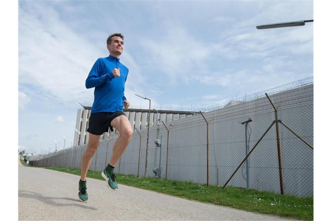 Marathon-Rekordler hofft auf Änderung der Olympia-Quali Arne Gabius läuft beim Training am Zaun der JVA Stuttgart-Stammheim vorbei. Foto: Marijan Murat/dpa/Archivbild