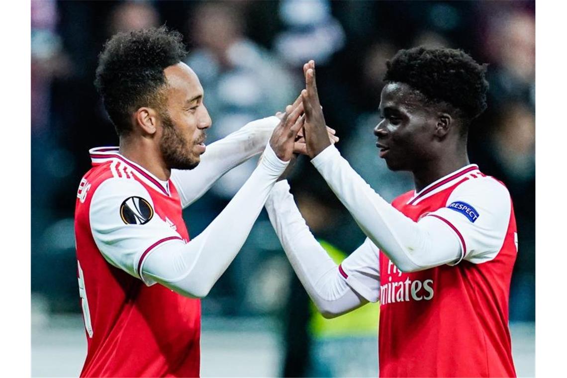 Arsenals Pierre-Emerick Aubameyang (l) und Londons Bukayo Saka jubeln über das Tor zum 0:3. Foto: Uwe Anspach