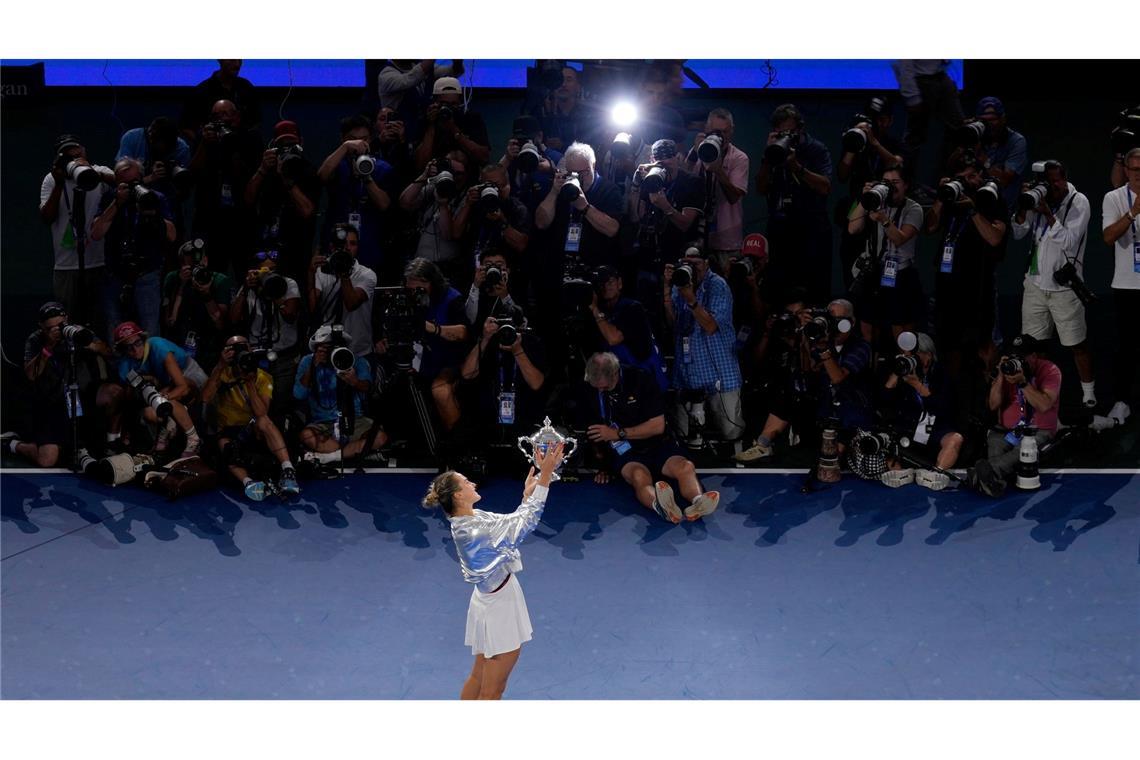 Aryna Sabalenka präsentiert den Fotografen ihren Pokal.