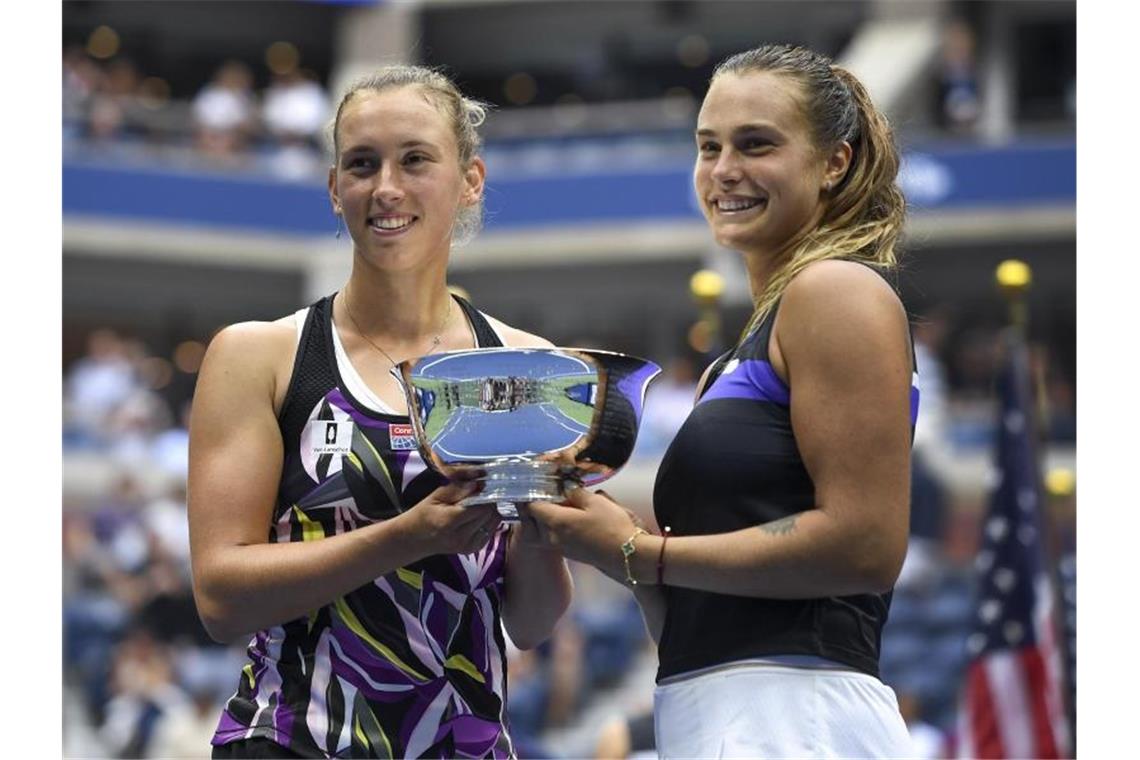 Aryna Sabalenka (r) und Elise Mertens halten nach ihrem Sieg im Doppel bei den US Open die Trophäe in den Händen. Foto: S. Stier/AP