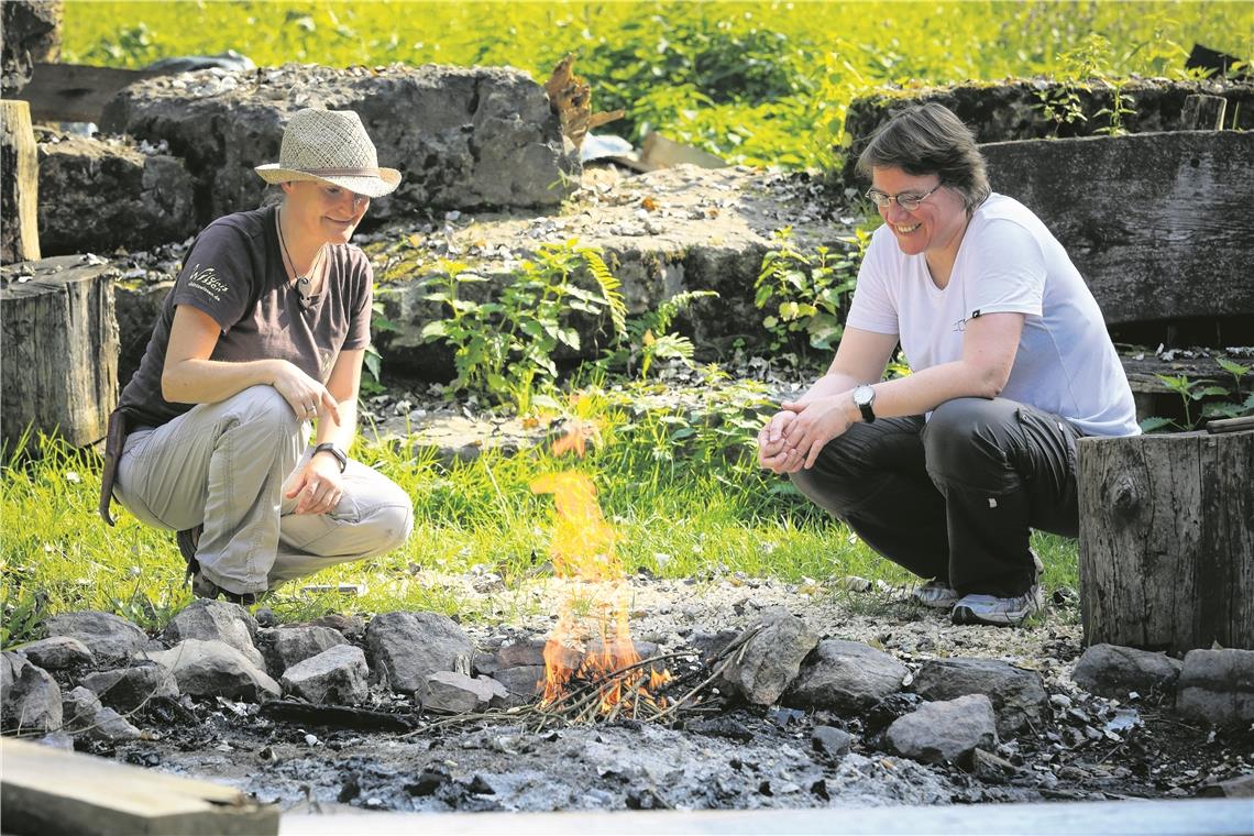 Astrid Szelest hat Redakteurin Christine Schick (von links) auf die Probe gestellt: Mit nur einem Streichholz ein Feuer entfachen. Die Freude ist groß, als es geklappt hat.