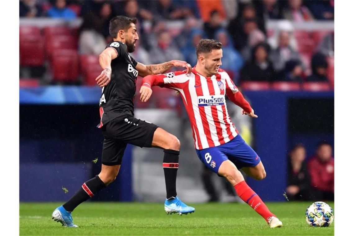 Leverkusen in Königsklasse vor dem Aus: Atlético zu clever Atléticos Saul Niguez setzt zum Schuss an, Kerem Demirbay kommt zu spät. Foto: Marius Becker/dpa