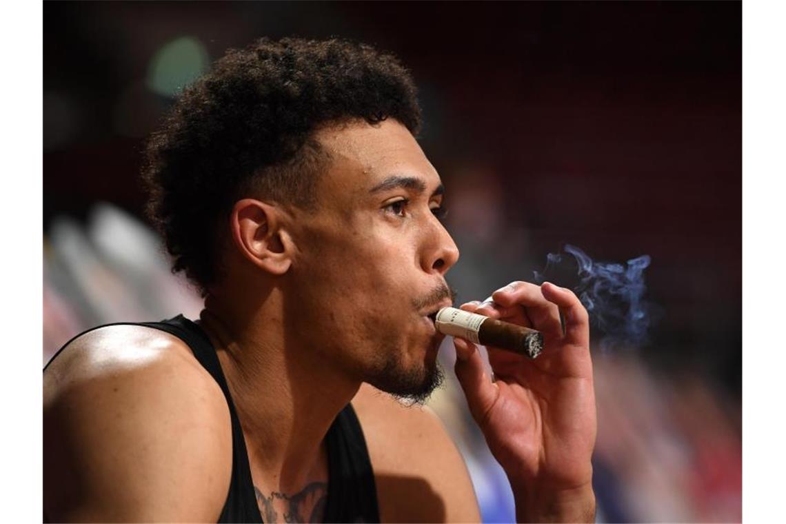 Bayern schreibt Basketball-Historie - „Das ist riesengroß“ Auch Bayerns Wade Baldwin zieht nach dem Spiel an einer Zigarre. Foto: Tobias Hase/dpa