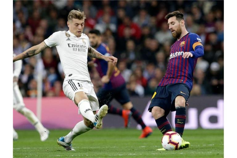 Auch für Toni Kroos (l) und Lionel Messi soll in Spanien der Ball bald wieder rollen. Foto: Andrea Comas/AP/dpa